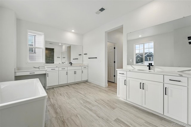 16549 Black Rose Cir, Parker, CO 80134 - bathroom featuring a sink, two vanities, walk in shower, a freestanding bath, and recessed lighting