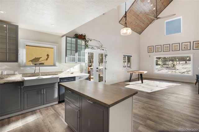 kitchen with hardwood / wood-style floors, dishwasher, sink, hanging light fixtures, and ceiling fan