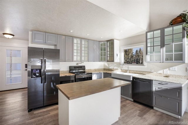 kitchen featuring appliances with stainless steel finishes, a kitchen island, gray cabinetry, and sink