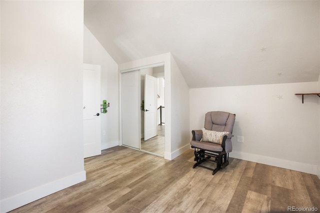 living area featuring hardwood / wood-style flooring and lofted ceiling