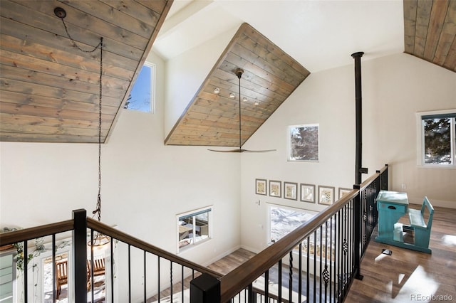 corridor featuring a healthy amount of sunlight, wooden ceiling, dark wood-type flooring, and vaulted ceiling