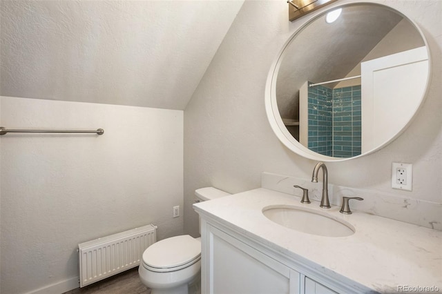 bathroom with vanity, toilet, radiator, and lofted ceiling