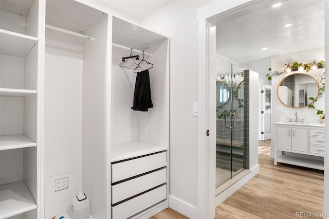 walk in closet with light hardwood / wood-style flooring and sink