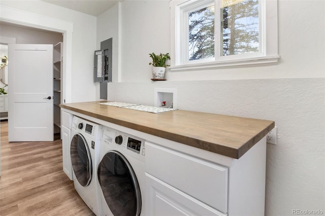 laundry room featuring washer and dryer, electric panel, and light hardwood / wood-style floors