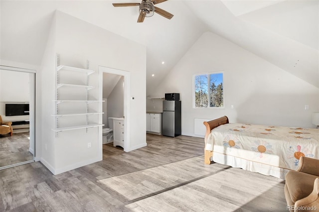 unfurnished bedroom with ensuite bath, vaulted ceiling, ceiling fan, light hardwood / wood-style flooring, and stainless steel refrigerator