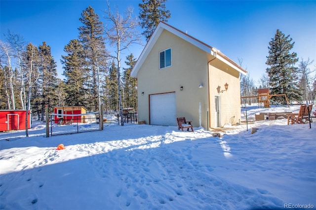 snow covered property featuring a garage