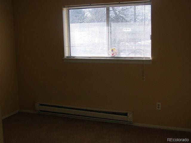 spare room featuring a healthy amount of sunlight and a baseboard radiator