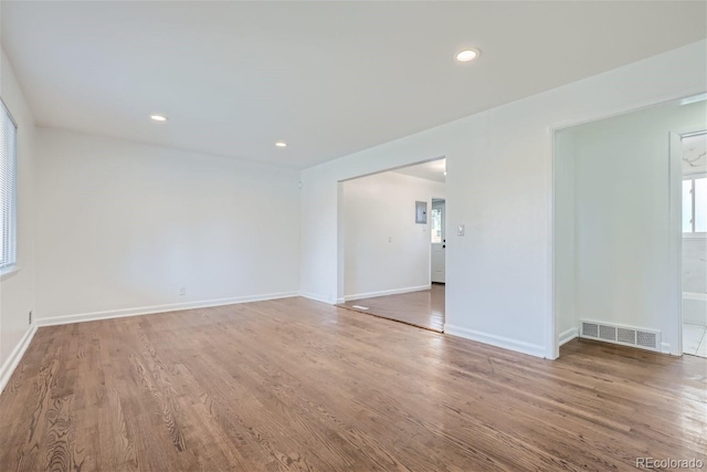 unfurnished room with baseboards, visible vents, wood finished floors, and recessed lighting