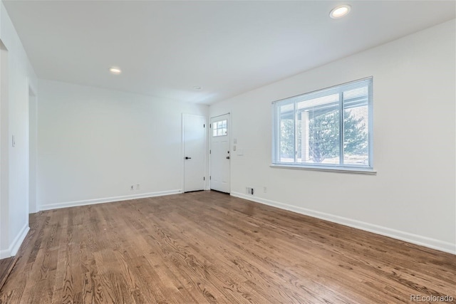 empty room featuring recessed lighting, wood finished floors, and baseboards