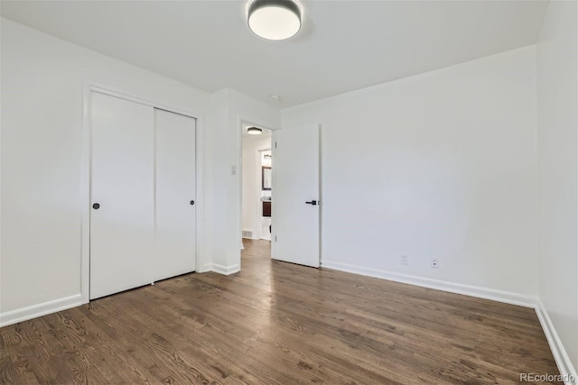 unfurnished bedroom with a closet and wood-type flooring