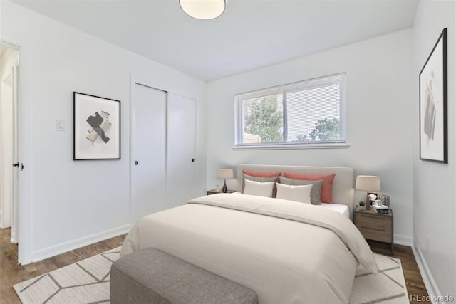 bedroom featuring a closet, light wood-style flooring, and baseboards