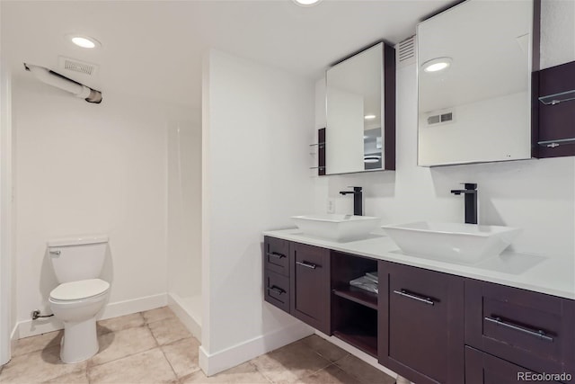 bathroom featuring walk in shower, tile patterned flooring, toilet, and double sink vanity