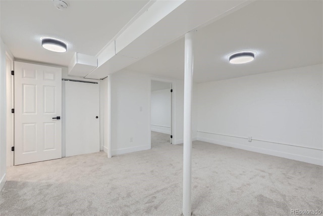 finished basement featuring light carpet and baseboards