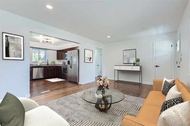 living room featuring dark wood-style floors, recessed lighting, and baseboards