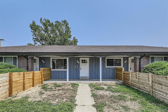 ranch-style home with board and batten siding and roof with shingles