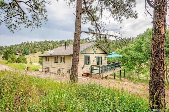 162 Pine Trl, Bailey, CO 80421 - rear view of property with a deck, a forest view, and roof with shingles