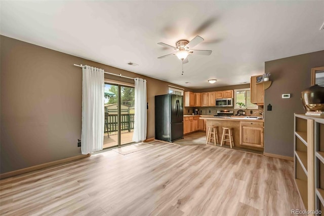 162 Pine Trl, Bailey, CO 80421 - kitchen featuring appliances with stainless steel finishes, a ceiling fan, light countertops, light wood finished floors, and a breakfast bar