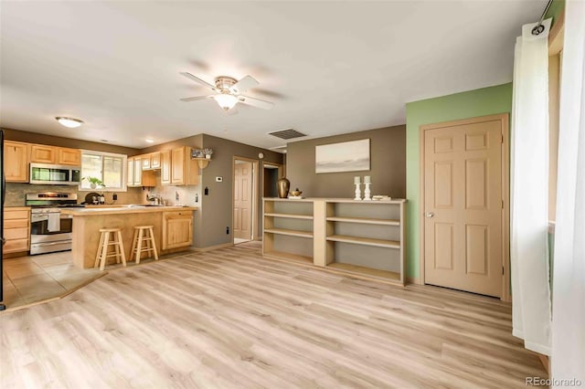 162 Pine Trl, Bailey, CO 80421 - kitchen with light brown cabinets, appliances with stainless steel finishes, a ceiling fan, and light wood-style flooring