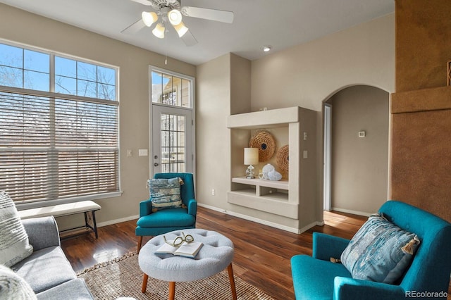 living room with dark wood-type flooring and ceiling fan