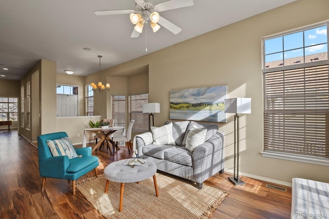 living room with wood-type flooring, ceiling fan with notable chandelier, and plenty of natural light