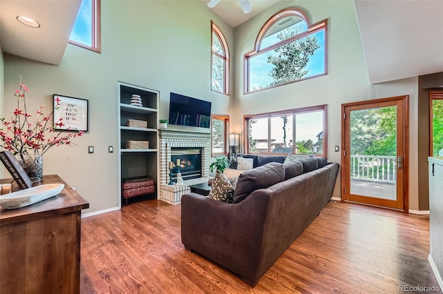 360 Morning Star Ln, Lafayette, CO 80026 - living room with a towering ceiling, healthy amount of natural light, wood finished floors, and a brick fireplace