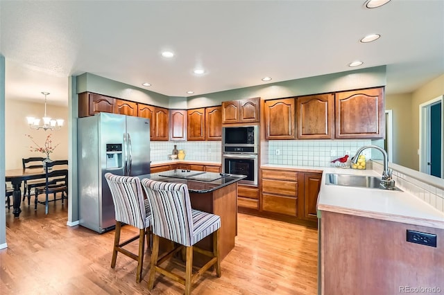 360 Morning Star Ln, Lafayette, CO 80026 - kitchen featuring stainless steel appliances, light wood finished floors, a breakfast bar, backsplash, and recessed lighting