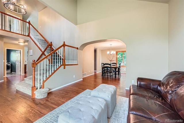360 Morning Star Ln, Lafayette, CO 80026 - living room with a chandelier, arched walkways, a towering ceiling, wood finished floors, and stairs