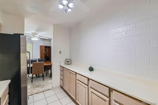 460 S Marion Pkwy Unit 102, Denver, CO 80209 - kitchen featuring freestanding refrigerator, ceiling fan, light tile patterned floors, light countertops, and light carpet