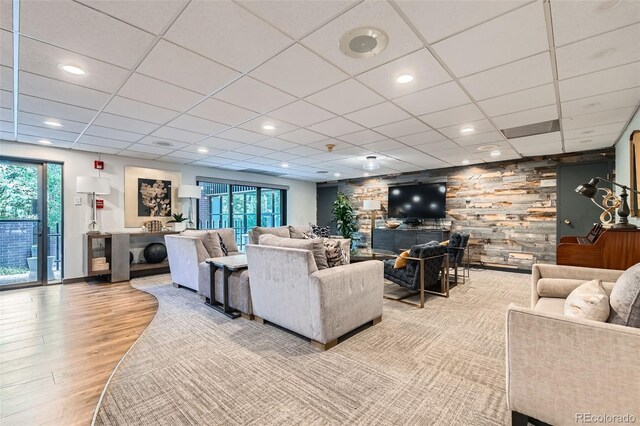460 S Marion Pkwy Unit 102, Denver, CO 80209 - living area featuring wood finished floors, healthy amount of natural light, a paneled ceiling, and wood walls