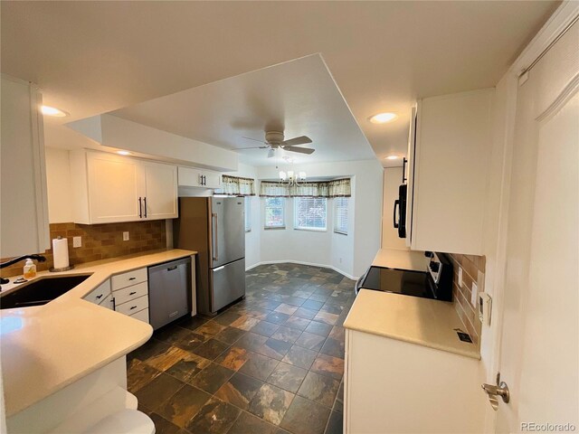 kitchen with dark tile patterned floors, tasteful backsplash, ceiling fan, appliances with stainless steel finishes, and sink