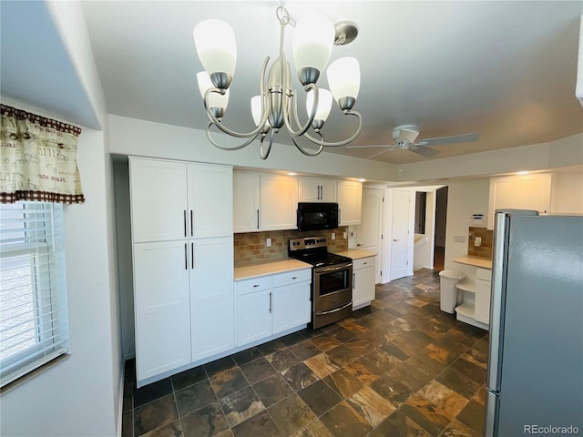 kitchen featuring white cabinetry, dark tile patterned floors, tasteful backsplash, ceiling fan with notable chandelier, and appliances with stainless steel finishes