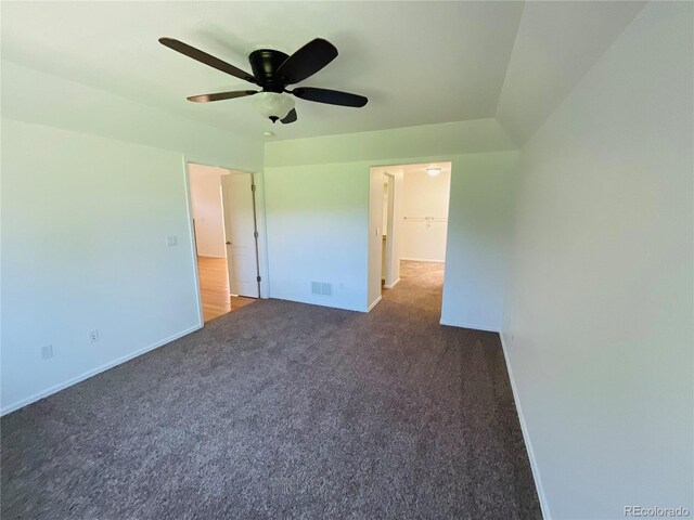 unfurnished bedroom with ceiling fan, light colored carpet, a closet, and a walk in closet