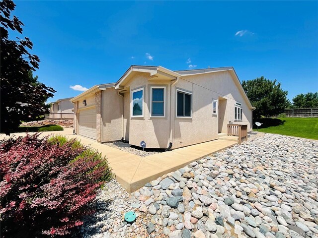 view of side of home featuring a garage and a patio area