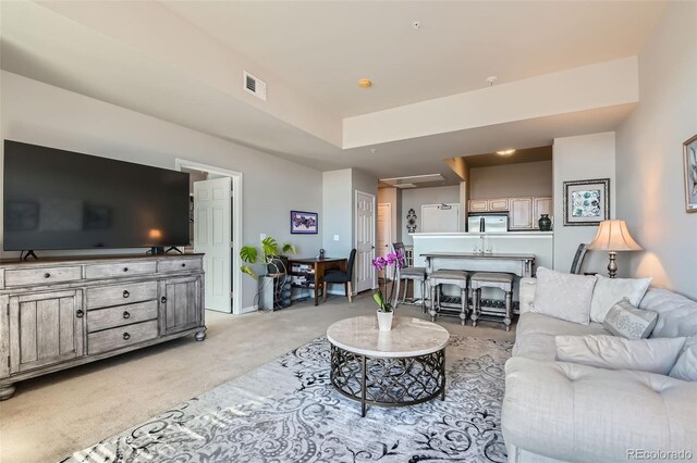 living area featuring light colored carpet and visible vents