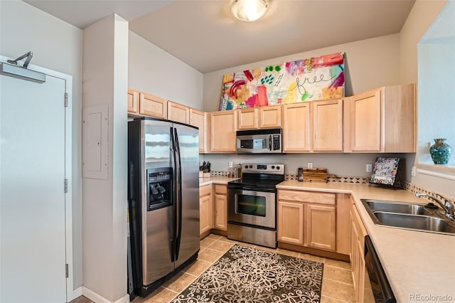 kitchen with stainless steel appliances, light countertops, light brown cabinets, and a sink