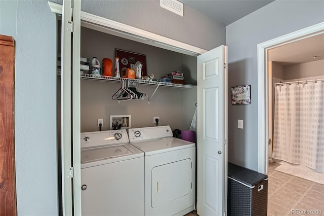 laundry area featuring laundry area, light tile patterned floors, visible vents, and washer and clothes dryer