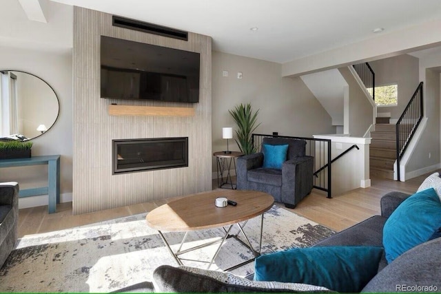 387 Bear Trl, Winter Park, CO 80482 - living area with wood finished floors, baseboards, a large fireplace, and stairs