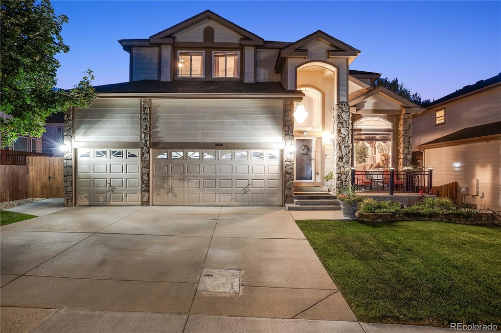 view of front of house featuring a garage and a lawn