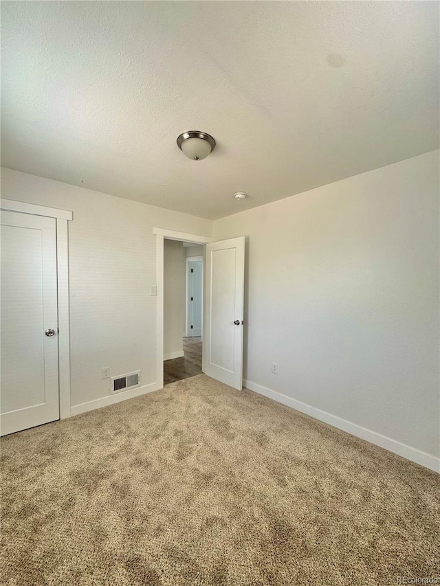 unfurnished bedroom featuring carpet and baseboards