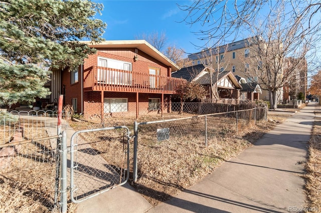 view of home's exterior with brick siding, a fenced front yard, and a gate