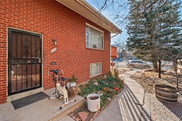 doorway to property featuring brick siding