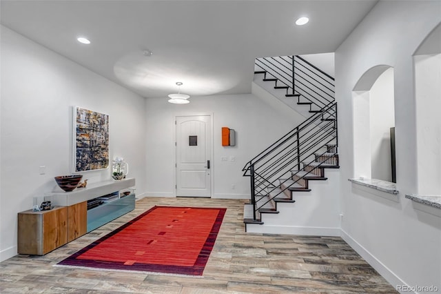 15902 W 64th Ave, Arvada, CO 80007 - entrance foyer with stairs, baseboards, wood finished floors, recessed lighting, and arched walkways