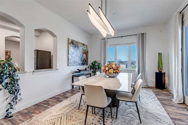 15902 W 64th Ave, Arvada, CO 80007 - dining room with wood finished floors, baseboards, and arched walkways