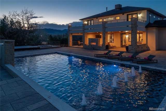 15902 W 64th Ave, Arvada, CO 80007 - pool at dusk with a patio area, an outdoor pool, and a mountain view