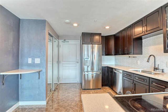 kitchen featuring appliances with stainless steel finishes, sink, backsplash, and dark brown cabinetry