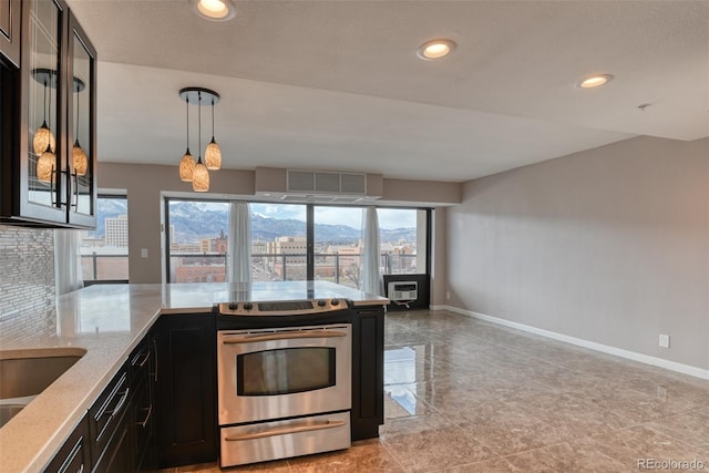 kitchen with pendant lighting, stainless steel electric range oven, backsplash, and a wealth of natural light