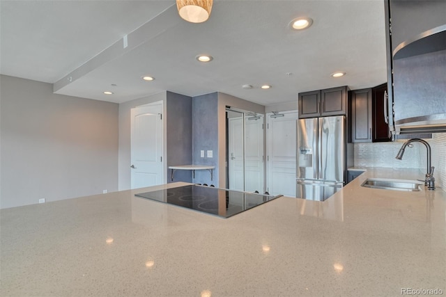 kitchen featuring dark brown cabinetry, stainless steel refrigerator with ice dispenser, sink, and black electric cooktop