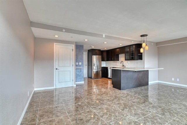 kitchen featuring sink, stainless steel appliances, a kitchen breakfast bar, decorative light fixtures, and kitchen peninsula