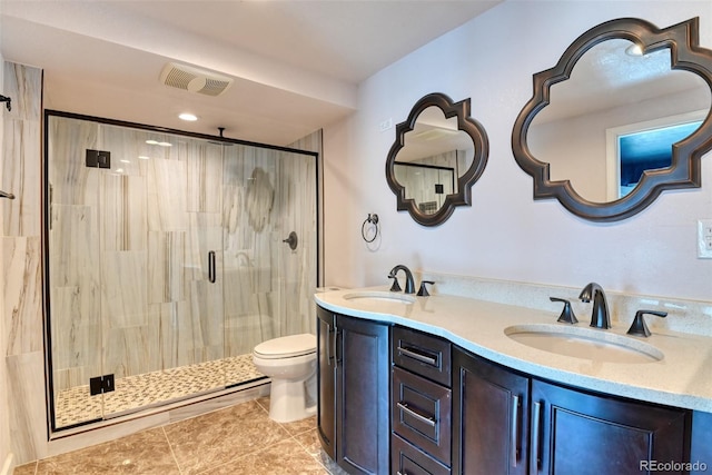 bathroom featuring vanity, toilet, tile patterned floors, and a shower with shower door