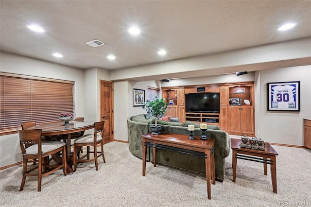 living area with light carpet, baseboards, and recessed lighting